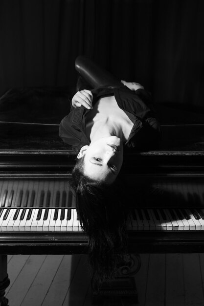 black-haired-woman-laying-black-piano_515281-342.jpg